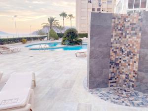 prysznic wyłożony kafelkami na środku patio z basenem w obiekcie Firstline apartment RUBINO Arenal-Bol Calpe w mieście Calpe