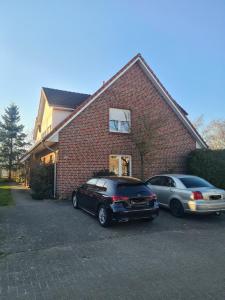 two cars parked in front of a brick house at Ferienwohnung 24 Oben Rechts 4 Zimmer in Lathen