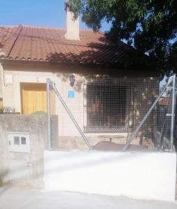 a house with a gate in front of a building at CASA DE LOS ABUELOS in Ortigosa del Monte