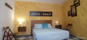 a bedroom with a bed and two chairs at Casa Monte Los Peñasquitos in Cazalla de la Sierra