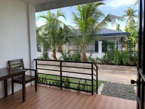 莫阿爾博阿的住宿－Palm Tree Lodge，客房设有带长凳和棕榈树的阳台。