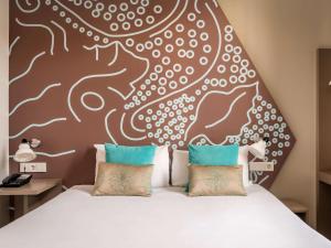 a bedroom with a bed with a large headboard at ibis Styles Barcelona Centre in Barcelona