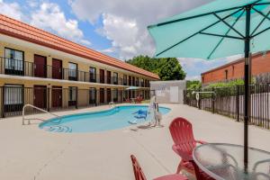 a pool with a table and chairs and an umbrella at Quality Inn Acworth in Acworth