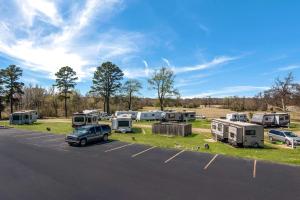 a parking lot with a bunch of rvs and a car at Rodeway Inn Broken Bow-Hochatown in Broken Bow
