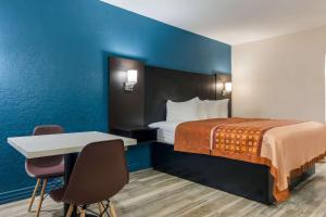 a hotel room with a bed and a table and chairs at Rodeway Inn Broken Bow-Hochatown in Broken Bow