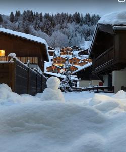 a snowman is standing in a pile of snow at Appartement 2 pièces Résidence les Fermes Emiguy Les Gets in Les Gets