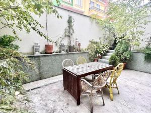 una mesa de madera y sillas en un patio en Housing León Unifamiliar con patio a 100 metros de la Catedral, en León