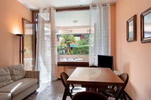 sala de estar con mesa, sofá y ventana en Arenzano pineta, en Arenzano