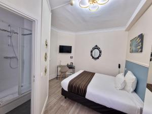 a hotel room with a bed and a bathroom at Hôtel Océanic - Grands Magasins in Paris