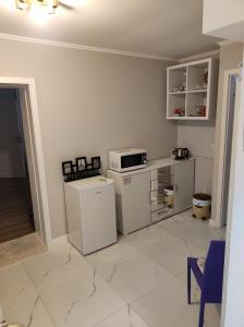 a white kitchen with a microwave and a refrigerator at Scandinavian Home in Bucharest City Center in Bucharest