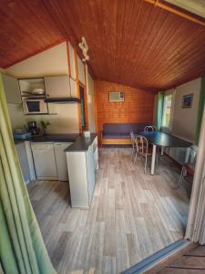 a kitchen and dining area of a tiny house at hôtel gites le clos du moulin in Terrasson-Lavilledieu