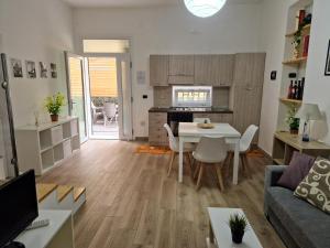 een keuken en een woonkamer met een tafel en stoelen bij Living Room Schiavonea in Marina di Schiavonea