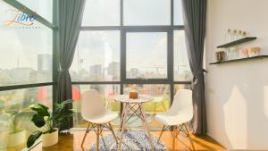 a table and chairs in a room with a large window at Libré Homestay in Hanoi