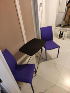 two purple chairs and a table in a room at Scandinavian Home in Bucharest City Center in Bucharest