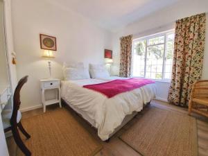 a bedroom with a large bed and a window at Palmview House in Hermanus