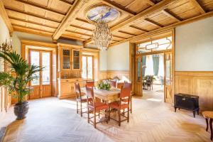VILLA CHIOVENDA Residenza d'Epoca في Premosello Chiovenda: غرفة طعام مع طاولة وكراسي