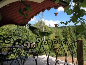 uma cerca de ferro forjado com vista para um jardim em La Tiny House de la Bergerie em Lierneux