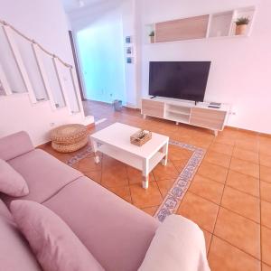 salon z kanapą i telewizorem w obiekcie Casa M de mar - Dúplex con vistas w Corralejo +37 zdjęć