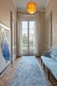 a living room with a couch and a large window at L'Apparthôtel Particulier Bordeaux in Bordeaux