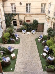 an outdoor patio with chairs and tables and a building at L'Apparthôtel Particulier Bordeaux in Bordeaux