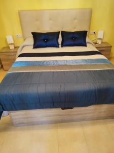 - une chambre avec un grand lit et des oreillers bleus dans l'établissement Casa Felisa, Vivienda de uso Turístico, à Fisterra