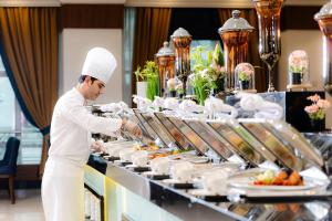 ein Koch bereitet Speisen am Buffet für Sie zu in der Unterkunft MADEN Hotel in Medina