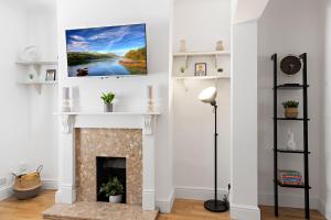 a living room with a fireplace and a tv on the wall at Church View in Dean
