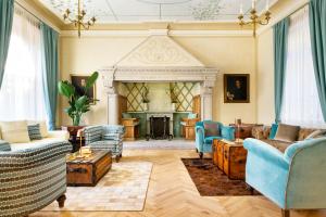 a living room with blue chairs and a fireplace at VILLA CHIOVENDA Residenza d'Epoca in Premosello Chiovenda