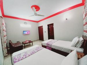 a hotel room with two beds and a ceiling fan at Gulshan Family Guest House Near Millennium Mall in Karachi