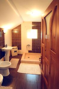 La salle de bains est pourvue d'une baignoire, de toilettes et d'un lavabo. dans l'établissement Casa de vacanta Isabelle, à Comarnic