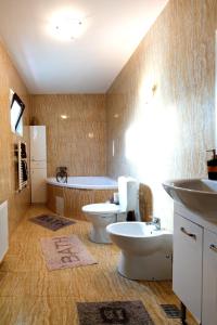 a bathroom with two toilets and a bath tub at Casa de vacanta Isabelle in Comarnic