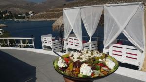 a plate of food on a table with a salad at Kazonis Studios in Kalymnos