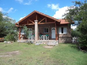 uma casa de madeira com um alpendre e um pátio em Wilka Pacha - Casas Serranas em Capilla del Monte