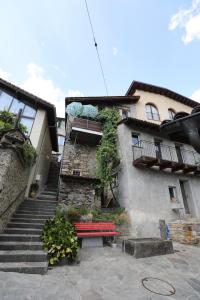 un bâtiment avec un banc rouge devant lui dans l'établissement Casa Holamundo - romantisches Tessiner Steinhaus (vegi), à Lugano
