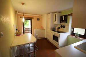 a kitchen with white cabinets and a counter top at Casa Holamundo - romantisches Tessiner Steinhaus (vegi) in Lugano