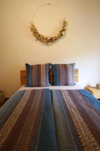 ein Schlafzimmer mit einem Bett mit einem Kranz an der Wand in der Unterkunft Casa Holamundo - romantisches Tessiner Steinhaus (vegi) in Lugano