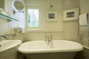 a white bathroom with a tub and a sink at The Star in Wantage