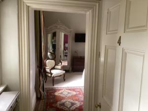 a hallway with a room with a chair and a door at Brynffynnon Boutique Bed and Breakfast in Dolgellau