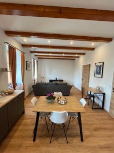 eine Küche und ein Wohnzimmer mit einem Tisch und einem Sofa in der Unterkunft T&T Apartments in Mönchmeierhof