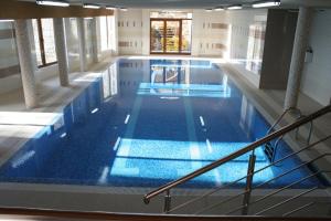 a large indoor swimming pool with blue water at Bubas in Kościelisko