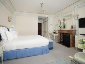 a bedroom with a white bed and a fireplace at The Ritz London in London