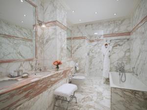 a bathroom with a tub and a toilet and a sink at The Ritz London in London