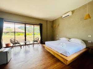 een slaapkamer met een bed, een tafel en stoelen bij The Liveliwoods in Khao Sok