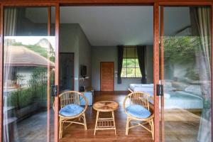 een kamer met twee stoelen, een tafel en een bed bij The Liveliwoods in Khao Sok