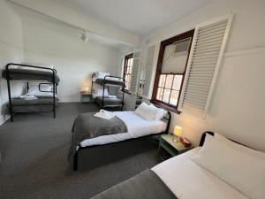 a bedroom with two beds and two windows at Hotel Concord in Sydney