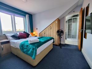 a bedroom with a large bed and a large window at Wellesley Hotel in Ilford
