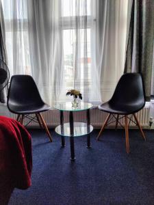 2 Stühle und ein Tisch vor einem Fenster in der Unterkunft Wellesley Hotel in Ilford