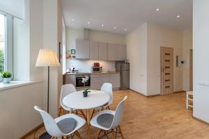 a kitchen and dining room with a table and chairs at Freedom avenue apartment by Polo Apartments in Kaunas