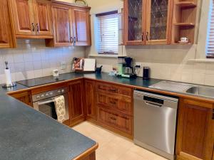 a kitchen with wooden cabinets and a stainless steel dishwasher at Aberdeen Cottage in Burra