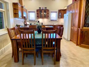 a kitchen with a table and chairs and a refrigerator at Aberdeen Cottage in Burra